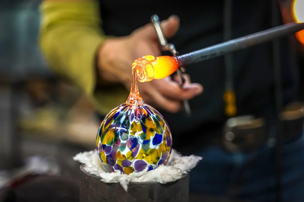 Glass-forming reference showing hot glass worked with a blowpipe