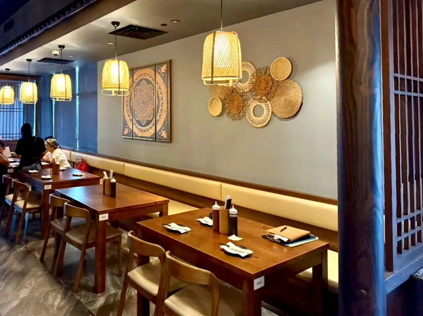 Timber dining furniture, woven pendants and a continuous wall treatment.