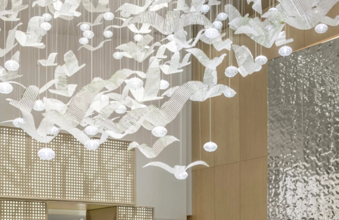 White bird-shaped crystal lighting installation suspended in a bright Shenyang show-house interior