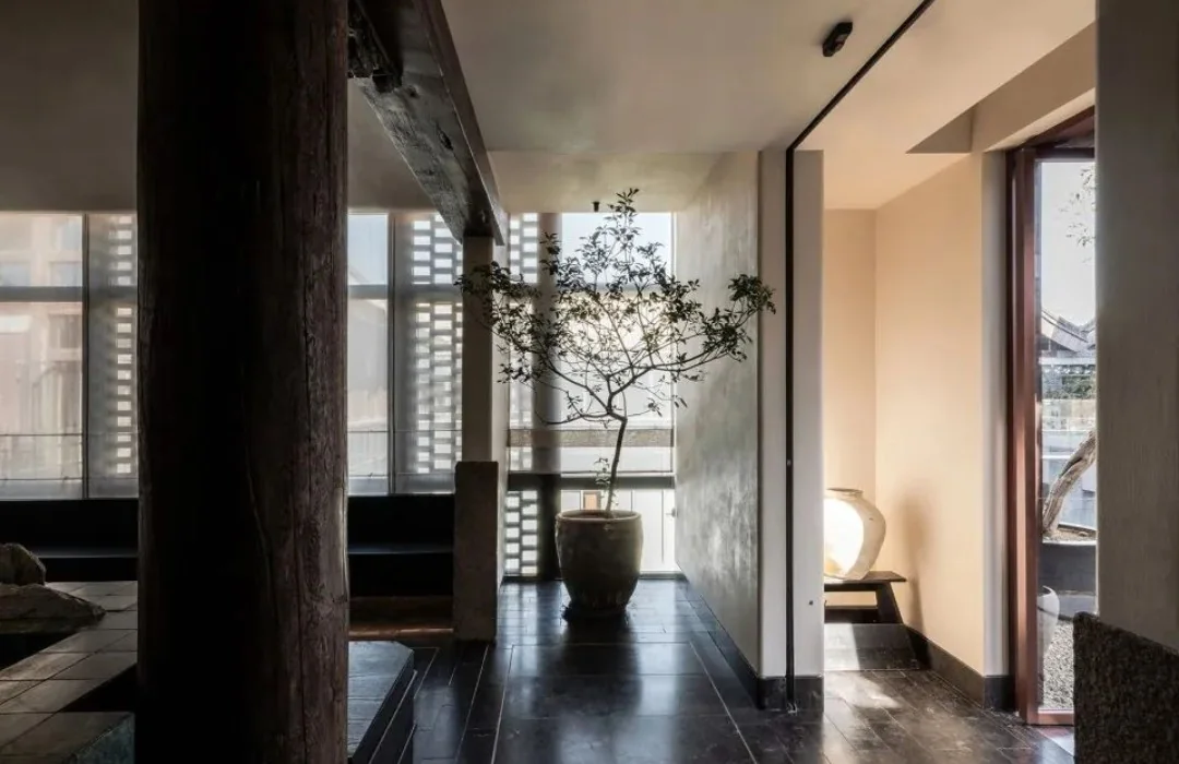 Restaurant corridor with layered light and a view towards planting