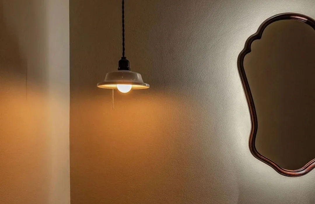 Small metal pendant against a warm-toned wall at Chulingyin Restaurant
