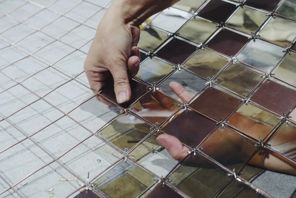 Hands positioning joints on a reflective glass and metal panel