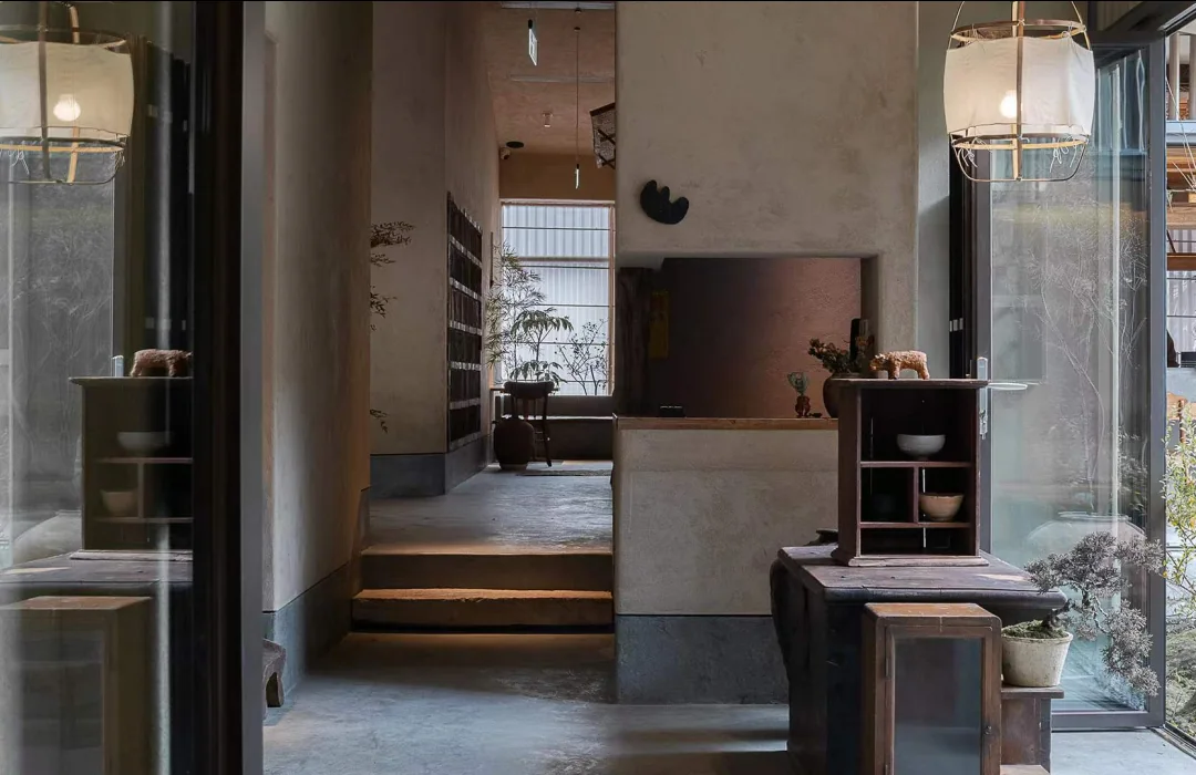 Yuangu Tea House interior with timber, translucent lanterns and a view into the courtyard