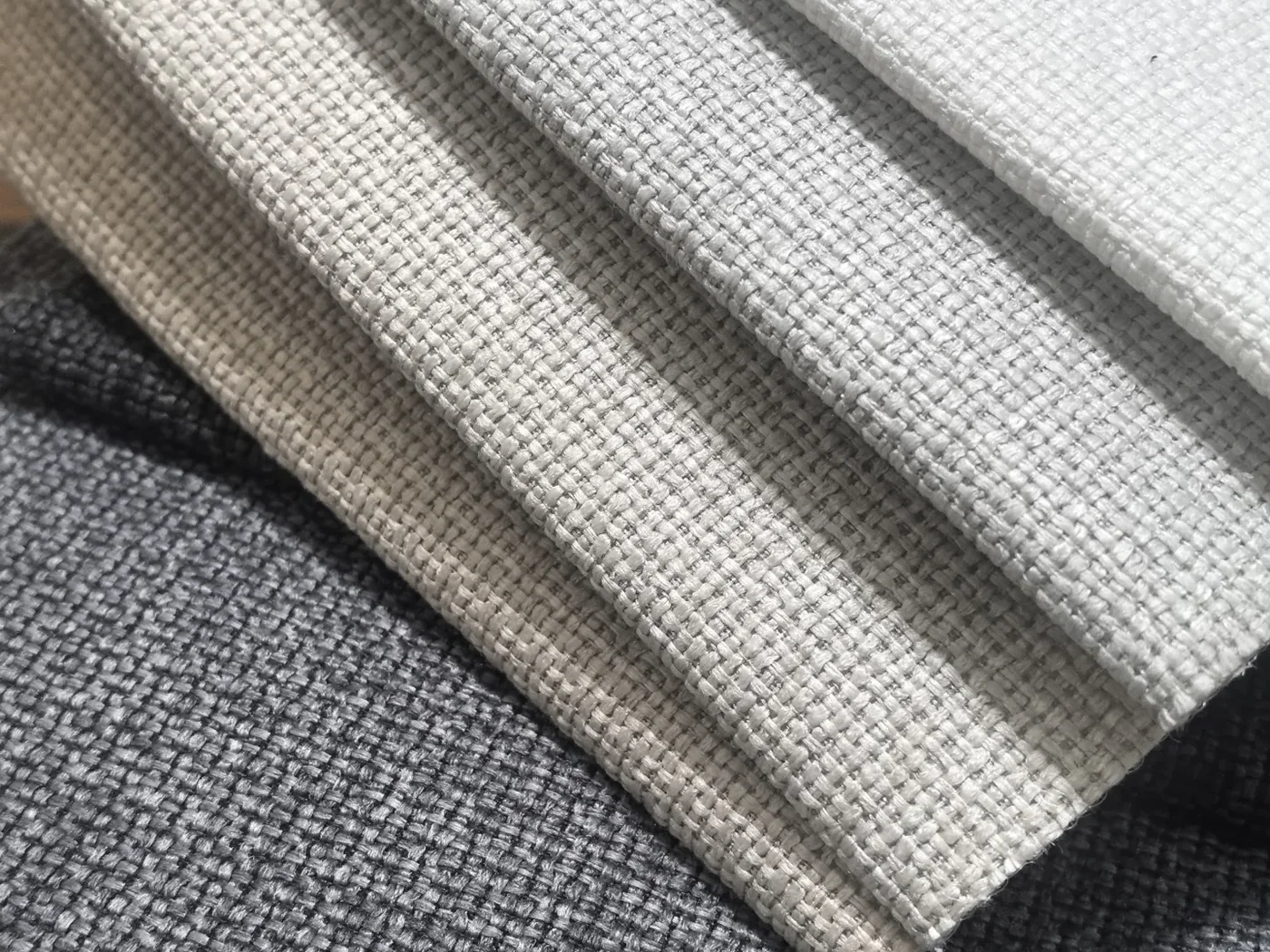 Neutral woven upholstery fabric swatches showing texture